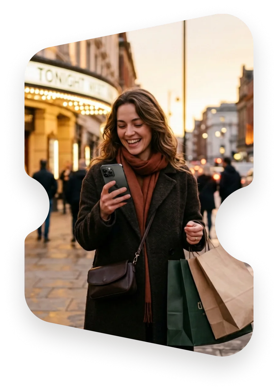 A visitor checking their phone outside a theatre